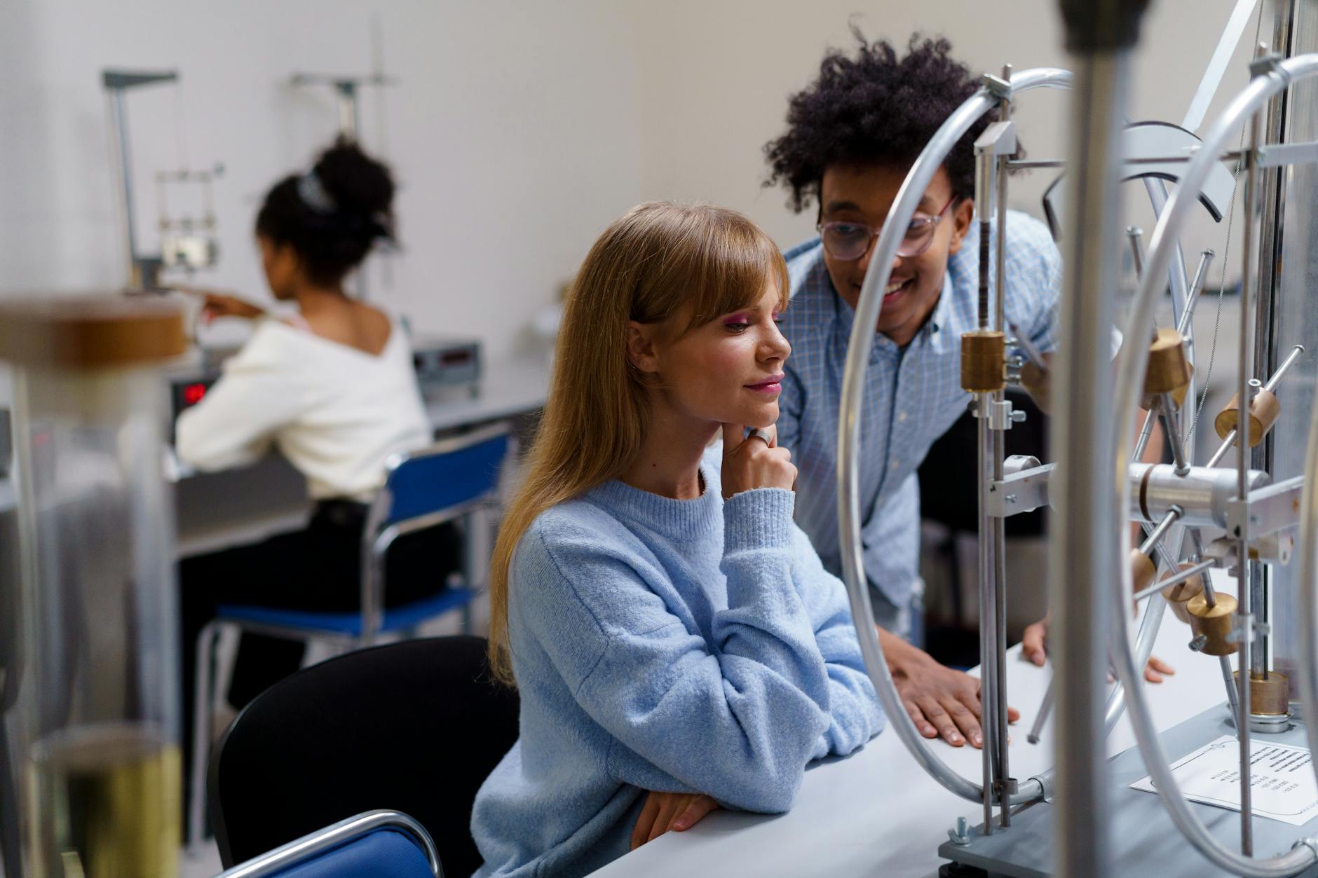 woman in blue sweater looking at a metal object