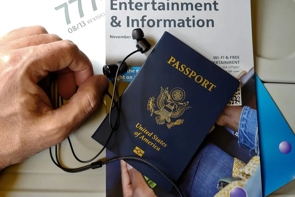 Close up of a Hand next to an American Passport with Headphones