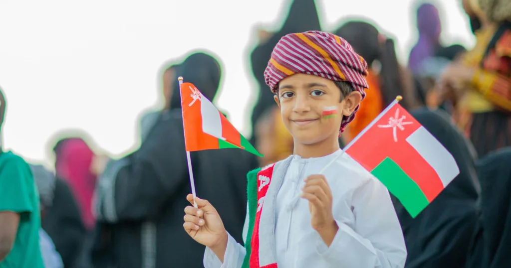 a happy kid with oman flag