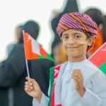 a happy kid with oman flag