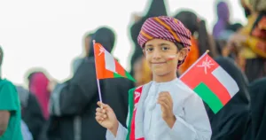a happy kid with oman flag